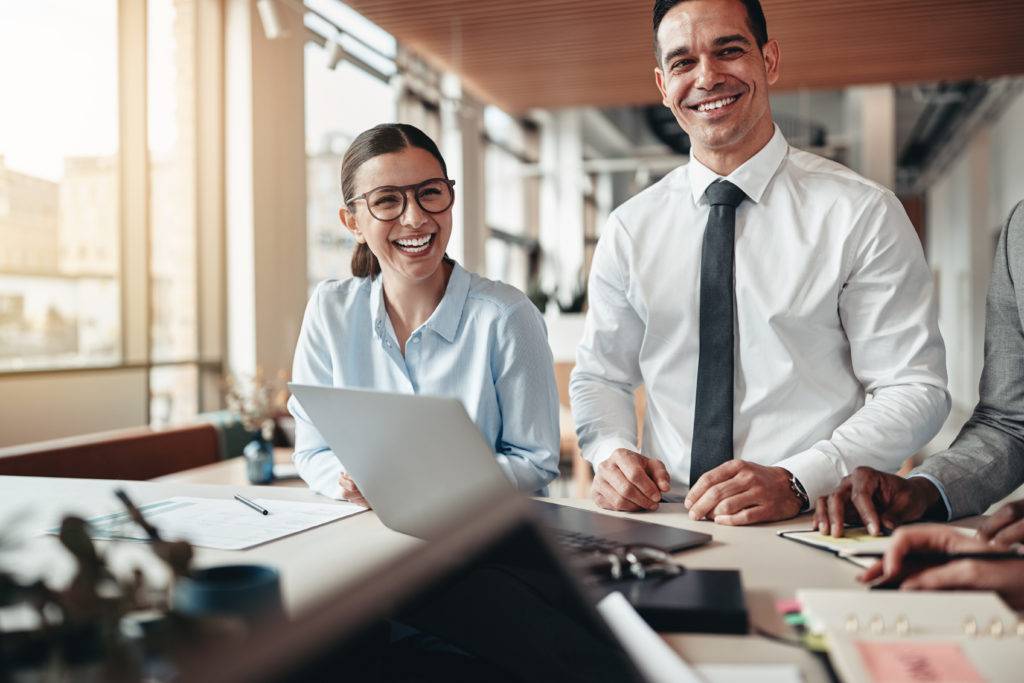 Two young businesspeople laughing during a meeting