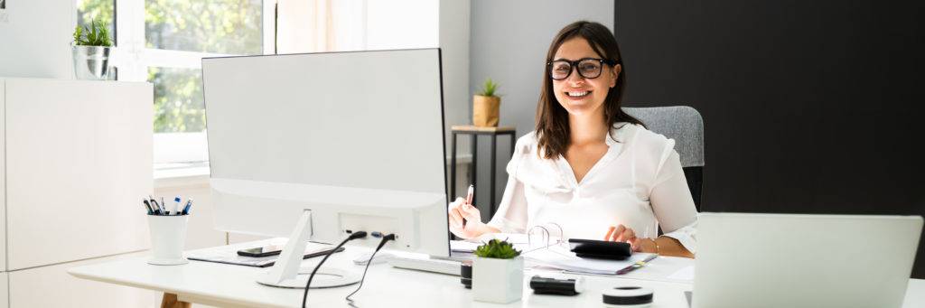 Female bookkeeper sitting at desk, smiling