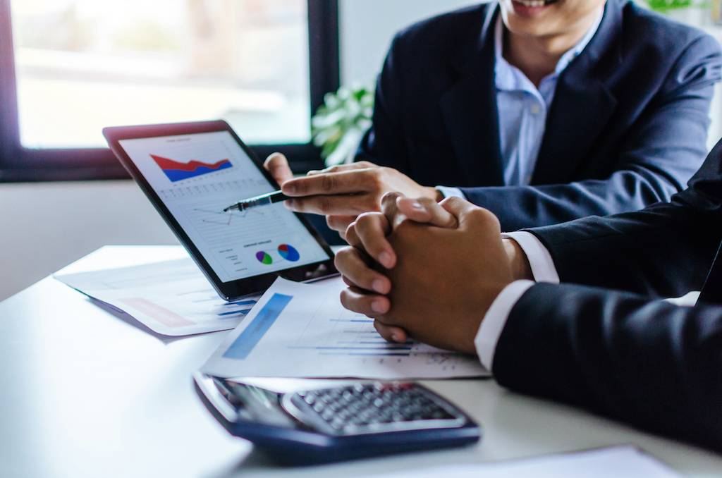 Two businessmen talking about financial statistics information